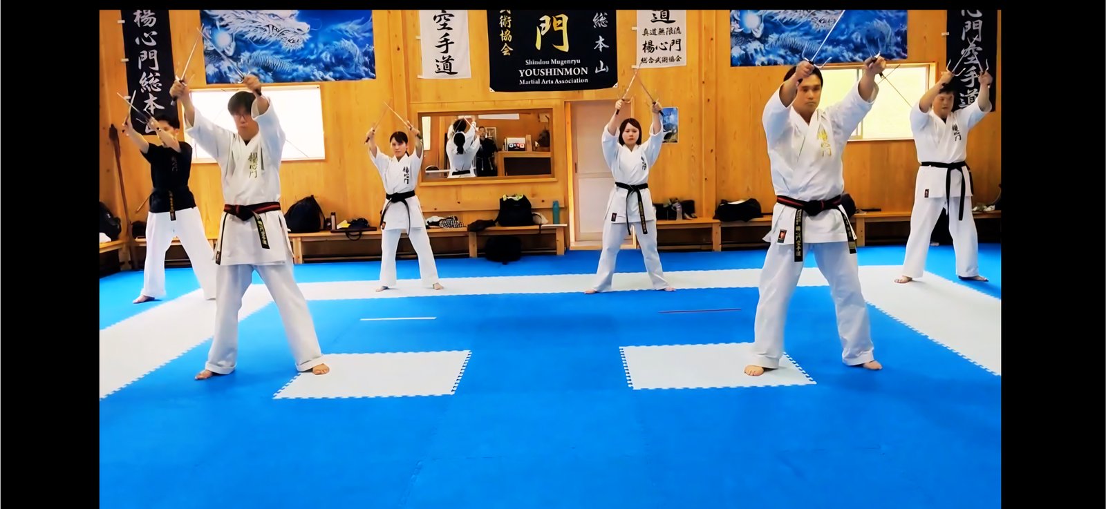 サイを高く掲げ演武する門下生たち