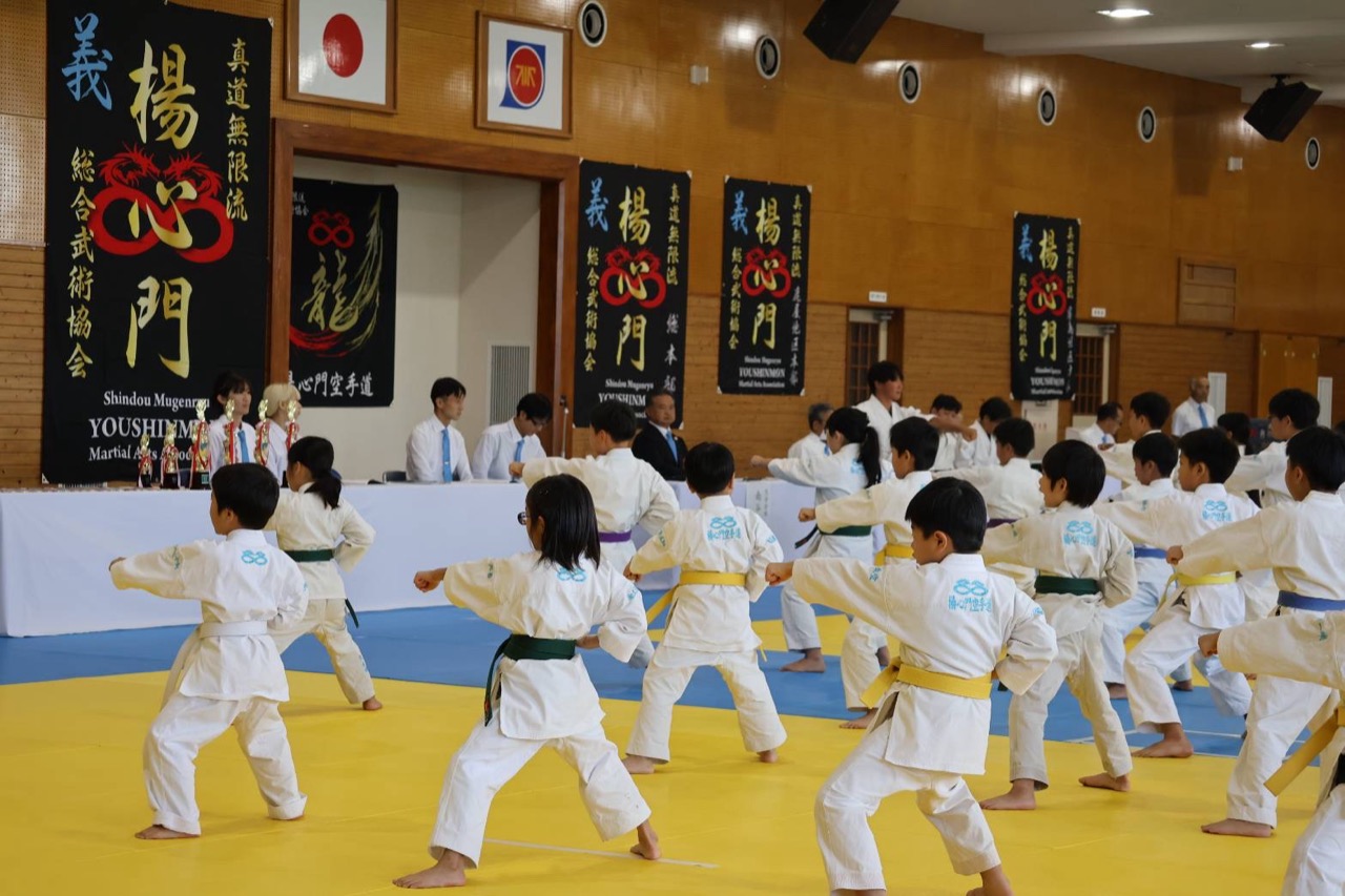 楊心門の道場旗が並ぶ会場で一斉に形を演武する門下生たち