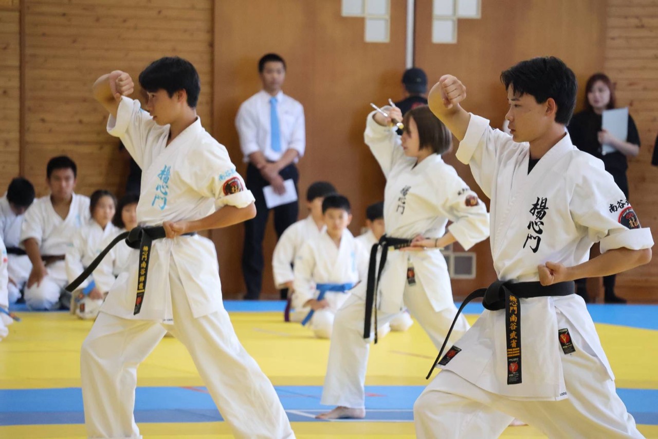 拳を高く構え気迫のこもった演武を見せる黒帯の門下生