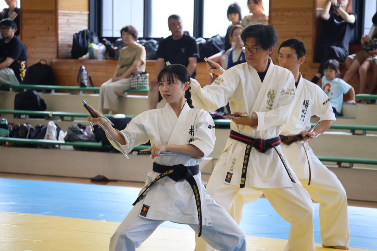 釵を構えて演武する門下生と指導者