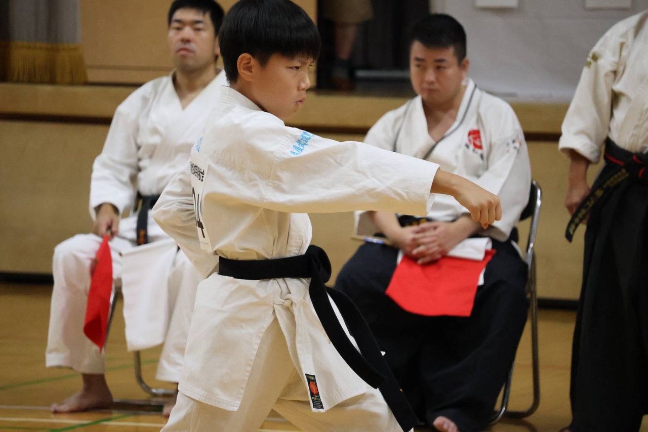 形の部で肘を引き受けの構えをとる門下生